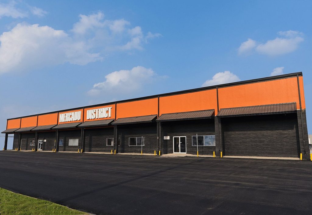 Image of a new warehouse named with a sign that reads“Mercado District” at the front.