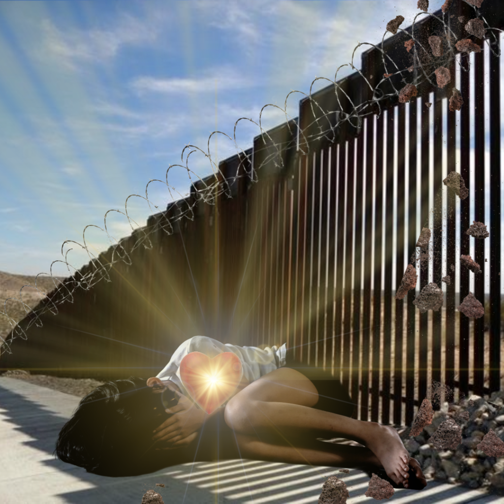 A young child covering their face as they lie down next to the border wall.