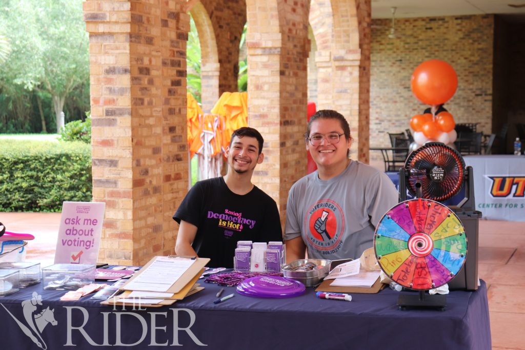 Two young people tabling at a voter registration event on their college campus.