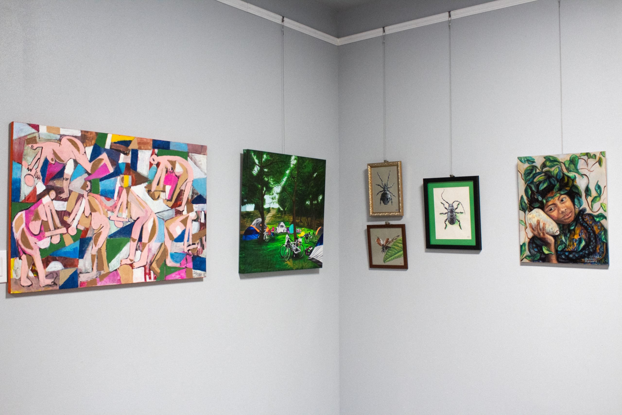 A photo of six artworks hanging on a studio’s walls.