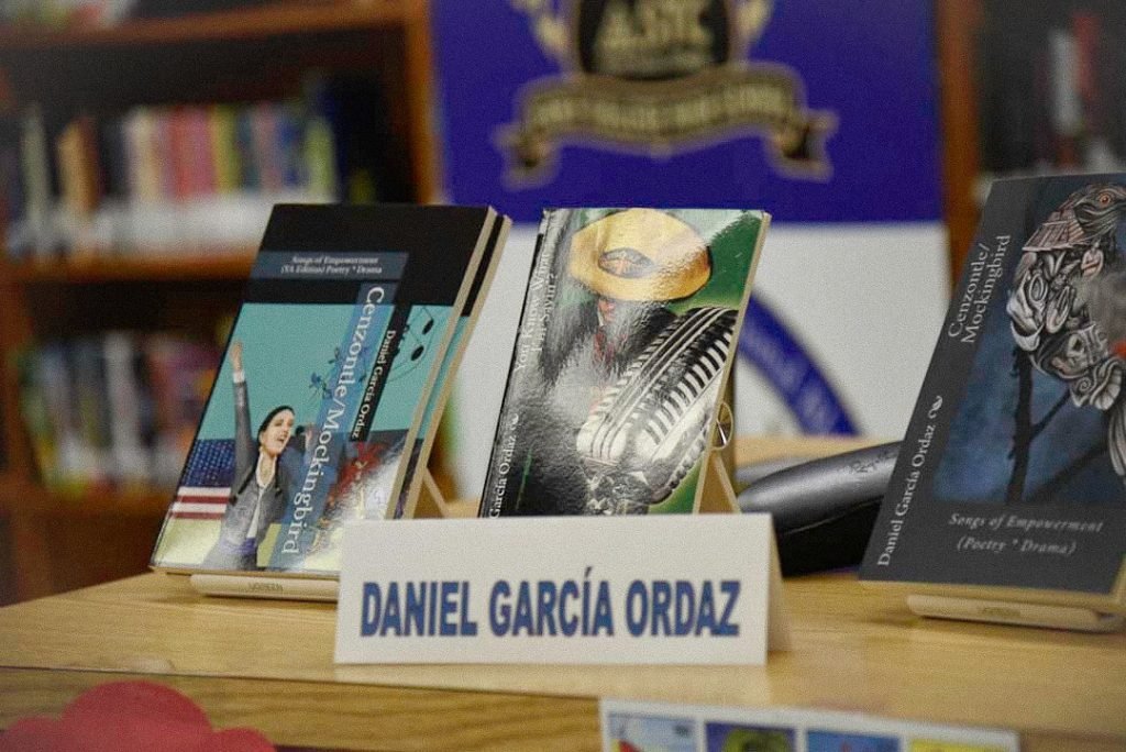 Three poetry books on a table with a man’s name on them.