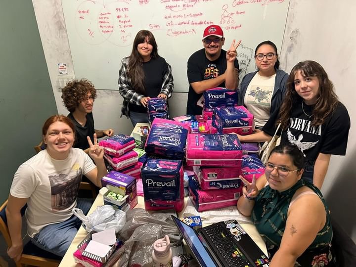 Students gathered around a table, posing for the camera.