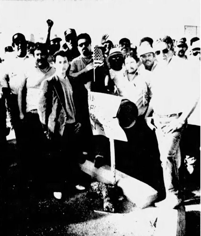 Black and white photograph of a group of men posing for a camera holding signs indicating a strike.