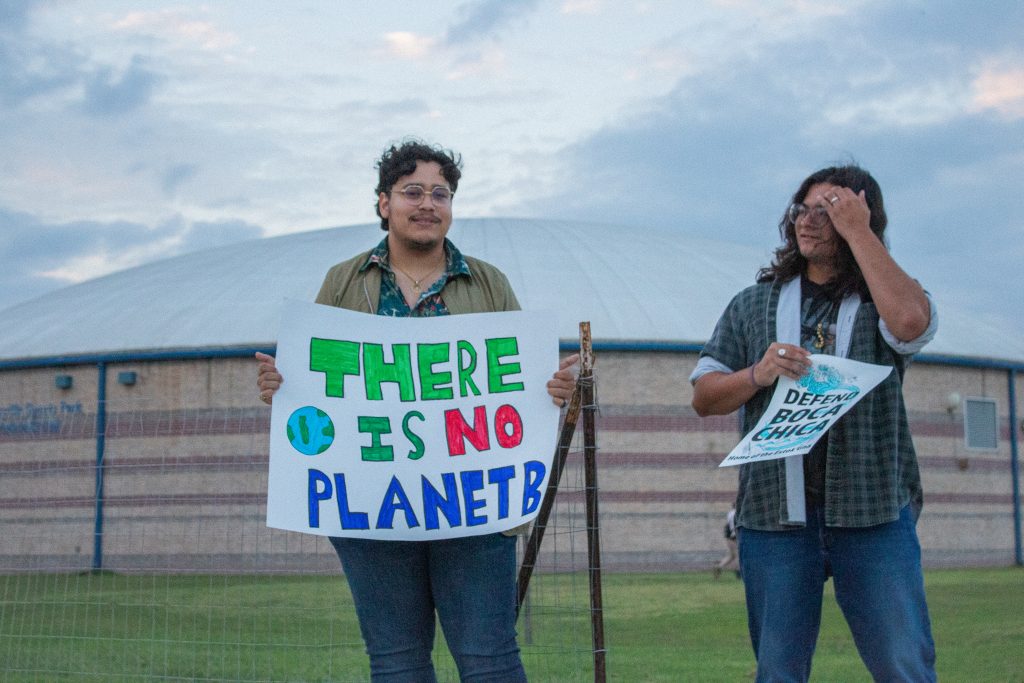 Two men hold banners while volunteering with SOTXEJN on Oct. 17.