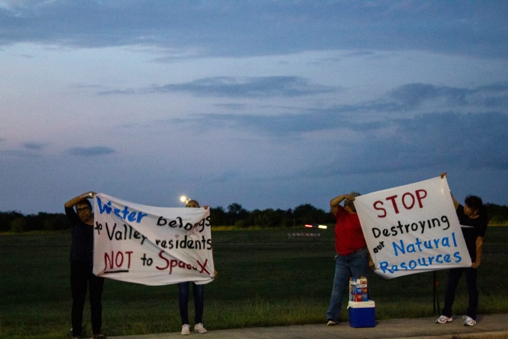 Four women protest outside the TCEQ public meeting on Oct. 17.