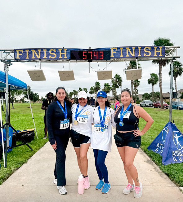 4 people are standing in front of a banner that says finish.