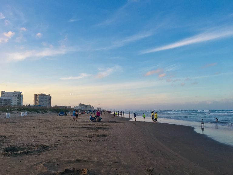 South Padre Island beach during a morning sunrise next to the seashore.