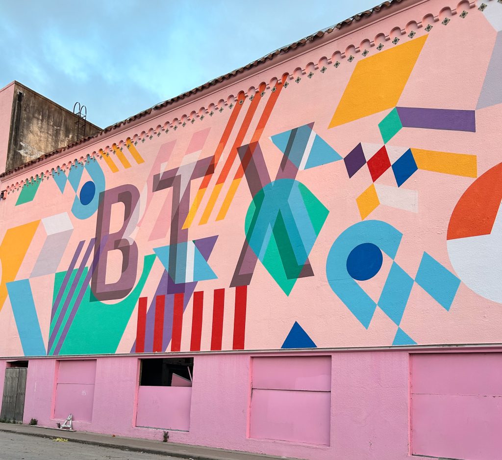 A pink mural with geometric shapes and the letters “BTX” written on it.
