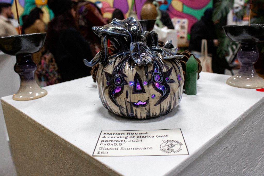 A small black, white, and blue ceramic carved pumpkin with lights inside.