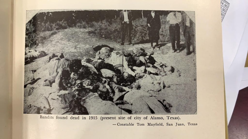 A black and white historical photo of bodies of bandits piled up dead in 1915 in Alamo, Texas.
