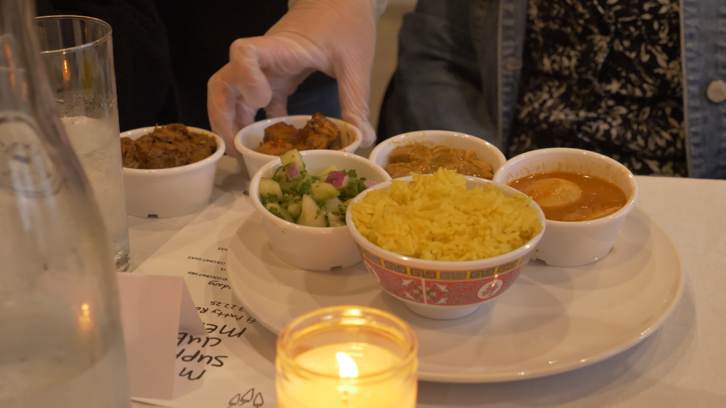 A meal laid out in front of a guest, small bowls with rice, proteins, and cucumber salad.