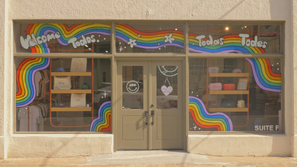 A colorful storefront with rainbows paintinted on their windows.