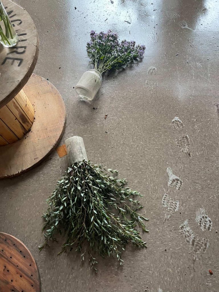Plants strewn on the floor with footprints tracking mud.