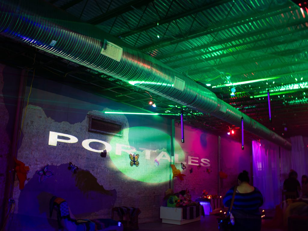 The inside of a building lit with vibrant purple, pink, and green lights.