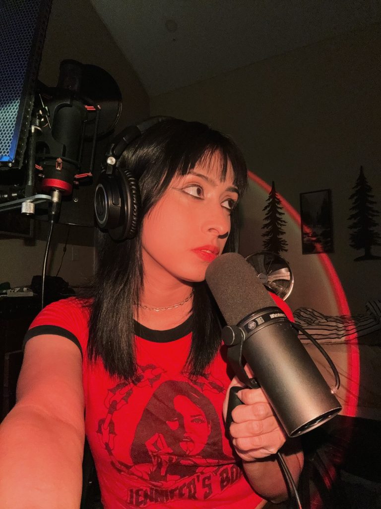 A young woman holding a microphone and wearing headphones.